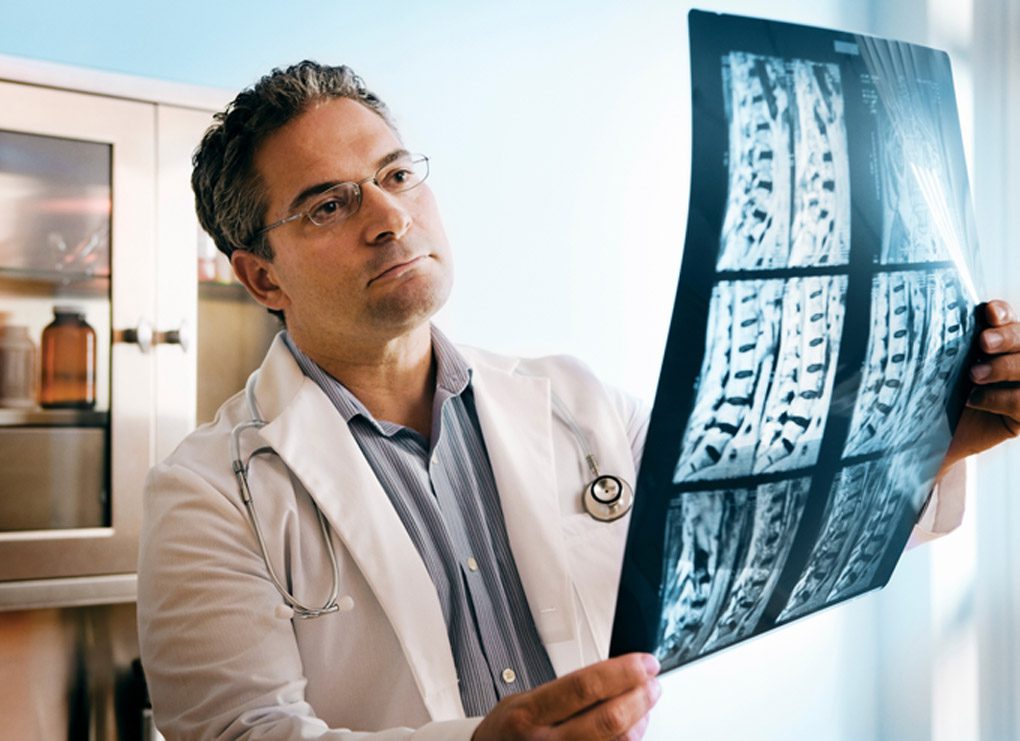 Doctor-evaluating-scan-of-spinal-cord-at-the-San-Antonio-injury-clinic